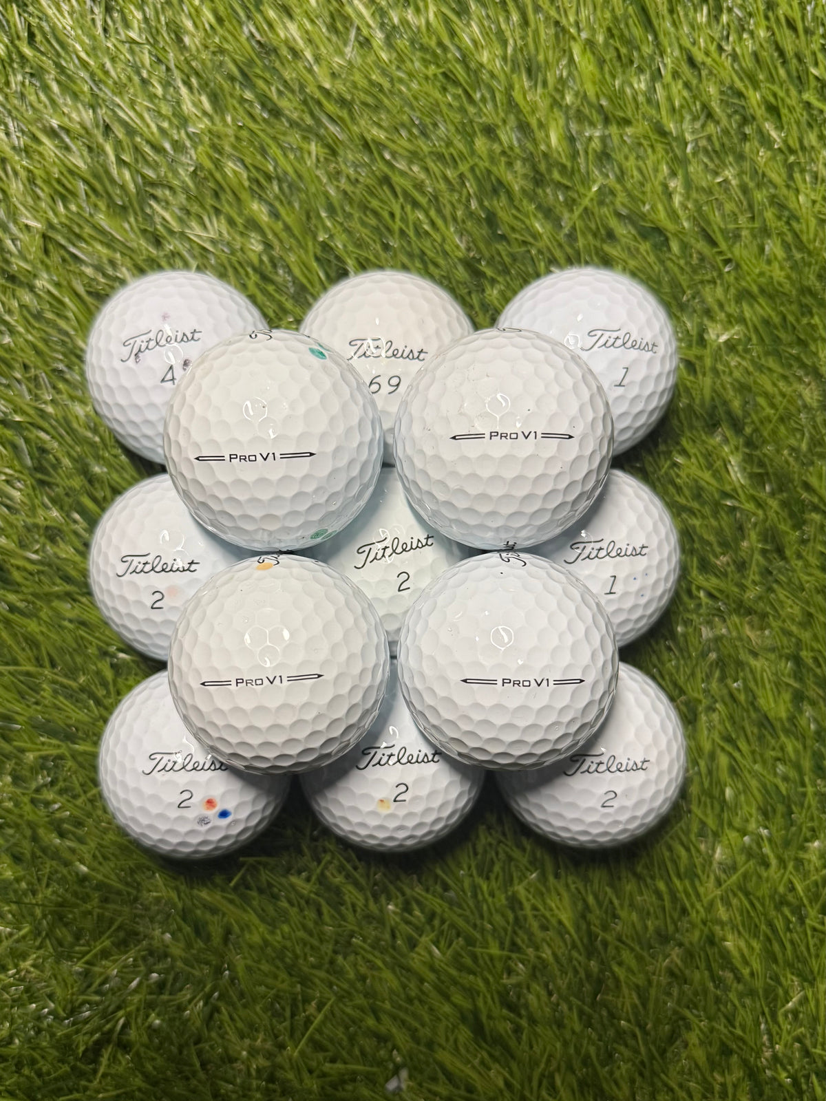 A/pearl grade Titleist Pro V1 golf balls arranged on the fairway