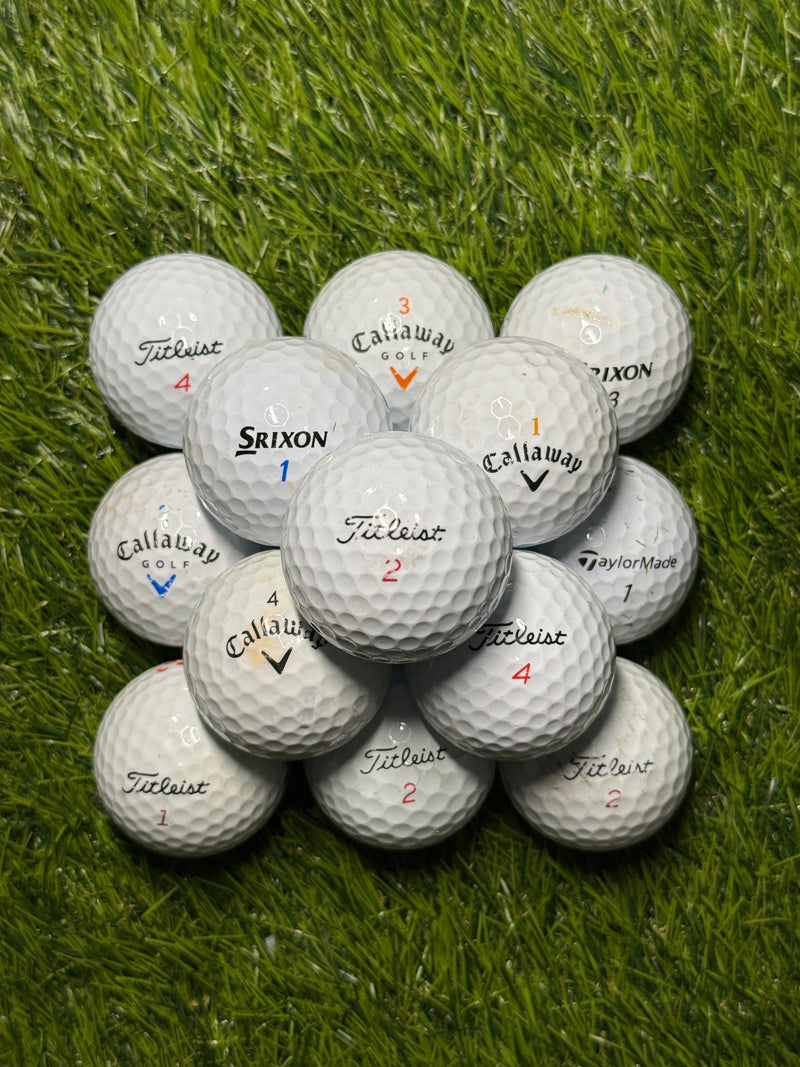 Premium brand golf ball mix in B grade stacked on grass