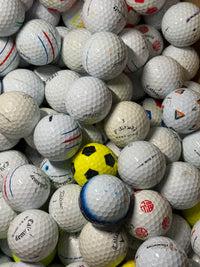 Close view of B and C grade premium golf balls including a yellow Truvis
