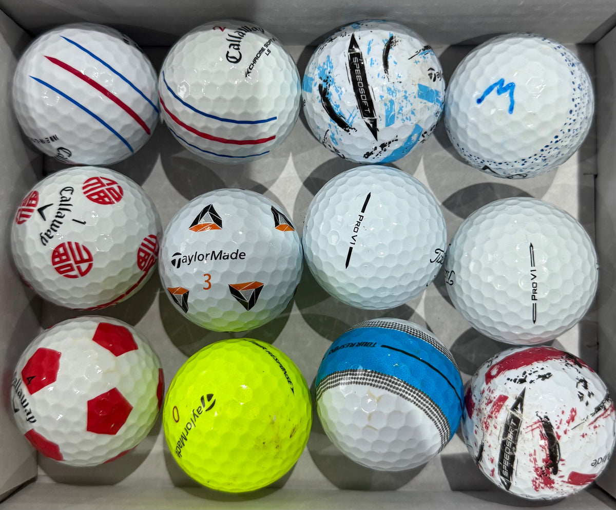 A-grade golf balls in a tray including Callaway and TaylorMade with alignment markings