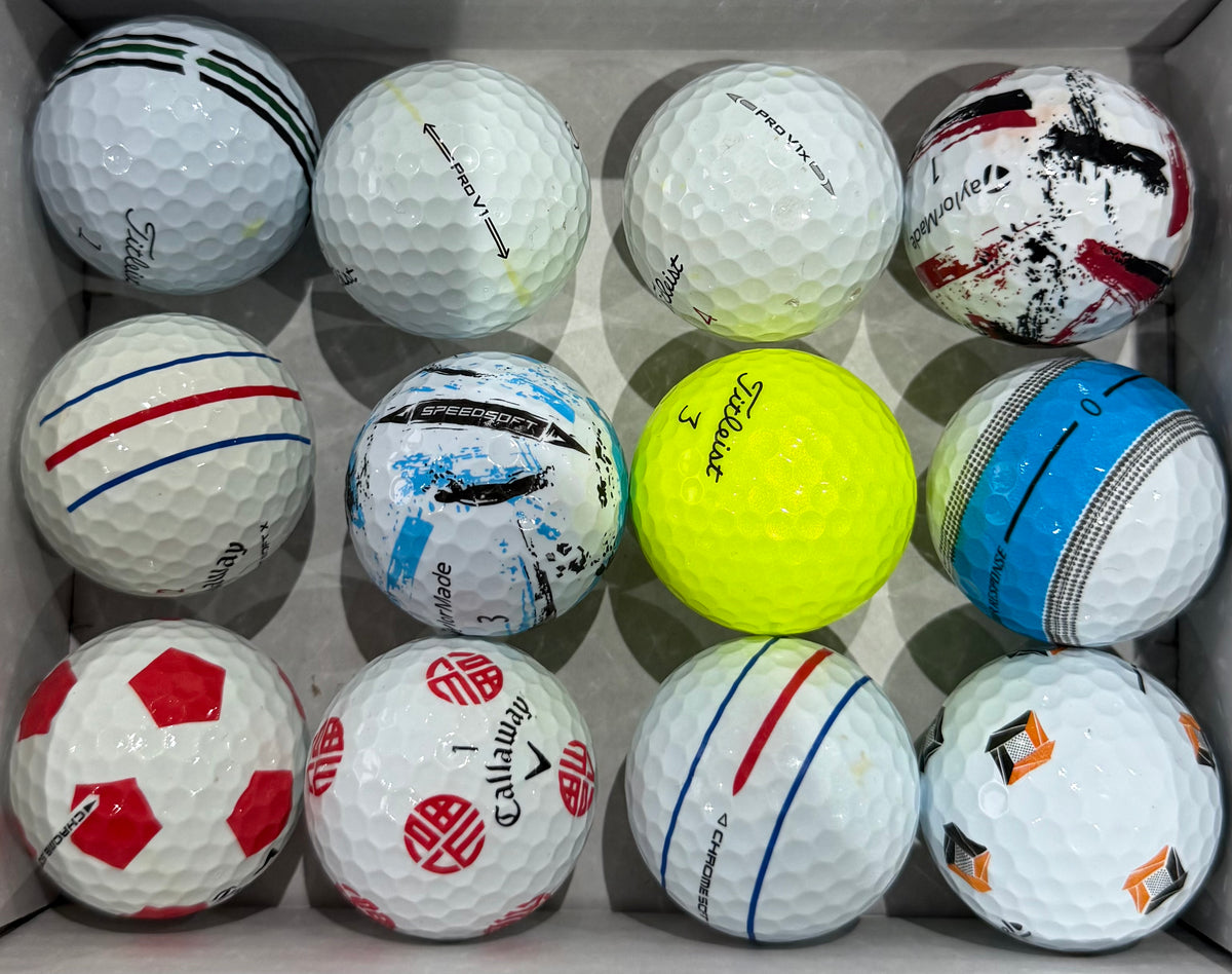 A-grade golf balls including a yellow Titleist and Callaway Truvis designs in a tray