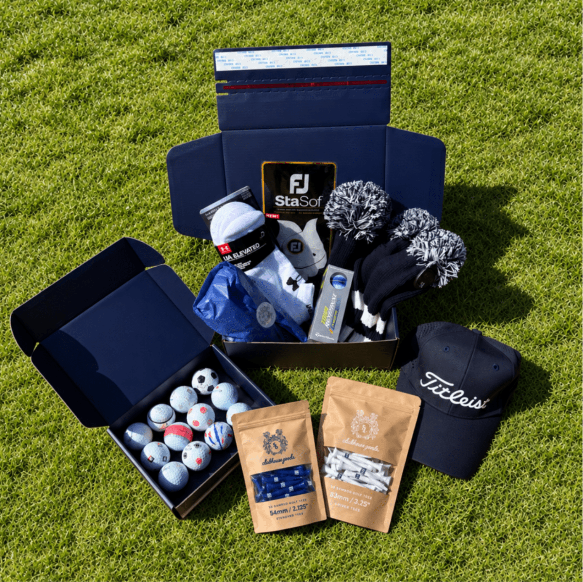 Presidential Mystery Box on grass with headcovers, a Titleist cap, glove, a dozen golf balls and tees