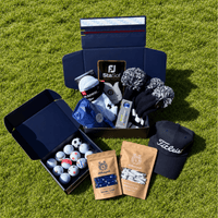Presidential Mystery Box on grass with headcovers, a Titleist cap, glove, a dozen golf balls and tees